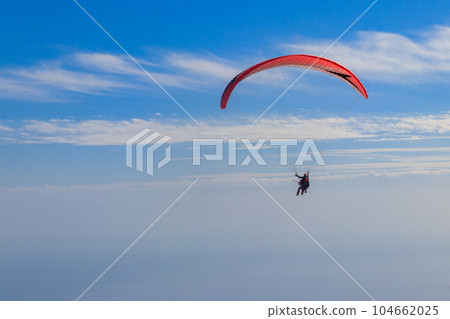 Paragliders in blue sky. Concept of active lifestyle and extreme sport adventure Paragliders in blue sky. Concept of active lifestyle and extreme sport adventure 104662025