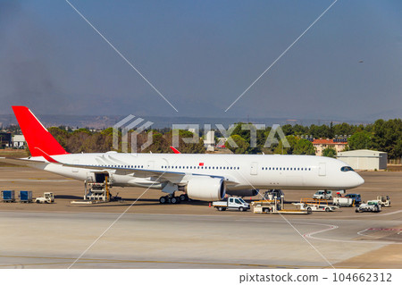 Busy airport with airplanes and service vehicles in Antalya, Turkey Busy airport with airplanes and service vehicles in Antalya, Turkey 104662312