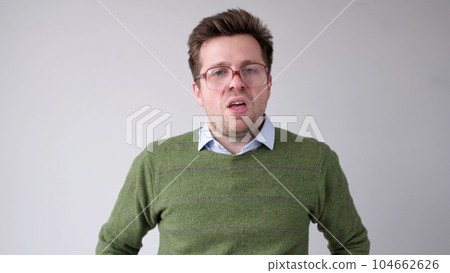 The angry European young man wearily looks. He is without strength and energy The angry European young man wearily looks. He is without strength and energy 104662626