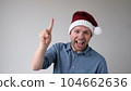 Funny Man in a New Year's Hat Counts Fingers, like Shows Numbers 104662636