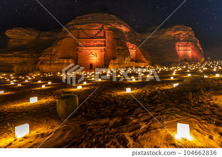 Guarded ancient tombs of nabataean Hegra Mada'in Salih city illuminated during the night, Al Ula, Saudi Arabia 104662836