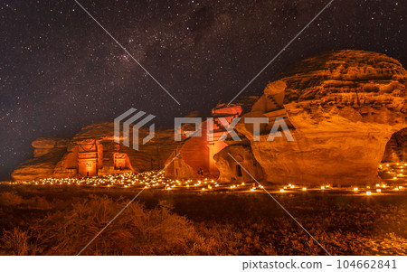 Starlight sky over the ancient nabataean tombs of Hegra city illuminated, night panorama, Al Ula, Saudi Arabia Starlight sky over the ancient nabataean tombs of Hegra city illuminated, night panorama, Al Ula, Saudi Arabia 104662841