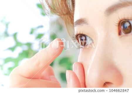 Young woman putting in contact lenses 104662847