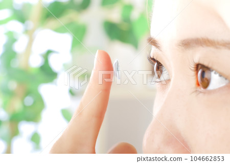Young woman putting in contact lenses Young woman putting in contact lenses 104662853
