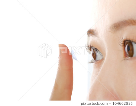 Young woman putting in contact lenses Young woman putting in contact lenses 104662855