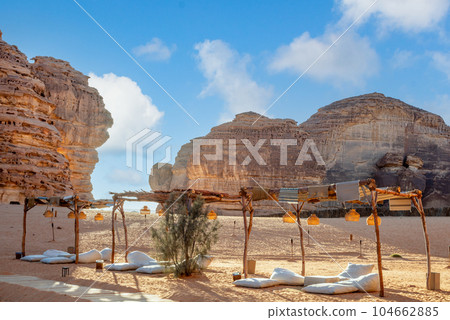 Outdoor lounge in front of elephant rock erosion monolith standing in the desert, Al Ula, Saudi Arabia 104662885