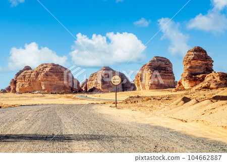 Desert road with slow sign and erosion canyon formations near Al Ula, Saudi Arabia Desert road with slow sign and erosion canyon formations near Al Ula, Saudi Arabia 104662887