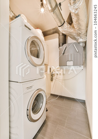 a laundry room with washer and dryer in the corner, which has been used as a storage space 104663245