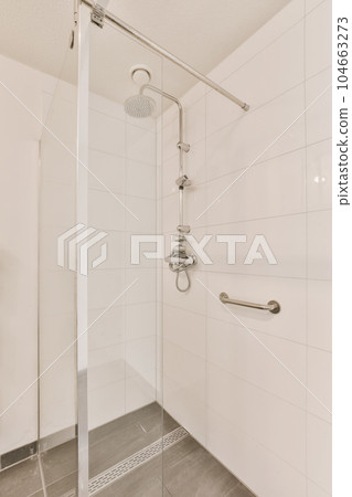a bathroom with white tile walls and gray flooring the shower is clean and ready to be used for use a bathroom with white tile walls and gray flooring the shower is clean and ready to be used for use 104663273