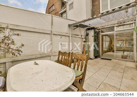 an outside area with a table, chairs and a tree in the middle of the patio looking out to the back yard an outside area with a table, chairs and a tree in the middle of the patio looking out to the back yard 104663544