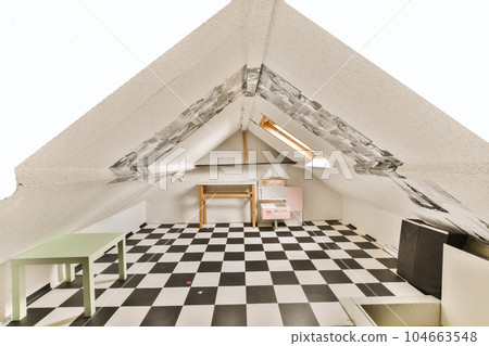a room with black and white checkered tiles on the floor in an attic - like space that has been used for many years 104663548