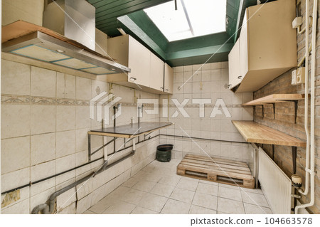 a kitchen that has been cleaned and is in need of some work to be done on the wall or ceiling 104663578