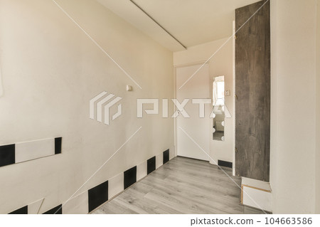 an empty room with white walls and black trim around the door to the right is a mirror on the wall 104663586