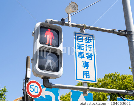 A traffic light (for bicycles and pedestrians only) and a blue sky. A traffic light (for bicycles and pedestrians only) and a blue sky. 104663661