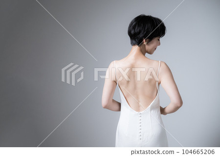 A woman with a beautiful back in a dress A beautiful woman looking back A woman with a beautiful back in a dress A beautiful woman looking back 104665206