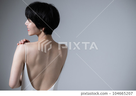 A woman with a beautiful back in a dress A beautiful woman looking back A woman with a beautiful back in a dress A beautiful woman looking back 104665207