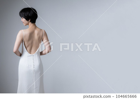 A woman with a beautiful back in a dress Beautiful woman looking back Copy space available on the right A woman with a beautiful back in a dress Beautiful woman looking back Copy space available on the right 104665666