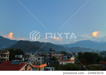 Pokhara, Nepal in South Asia View of Machhapuchare and the Annapurna Mountains at dawn from the roof of a city building 104665670