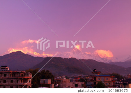 Pokhara, Nepal in South Asia View of Machhapuchare and the Annapurna Mountains at dawn from the roof of a city building 104665675