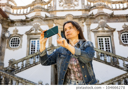 Woman photographing with her smartphone at Mateus Palace in Vila Real Woman photographing with her smartphone at Mateus Palace in Vila Real 104666278