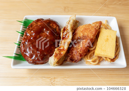 Japanese hamburger steak, fried fish and Japanese rolled omelet on white plate Japanese hamburger steak, fried fish and Japanese rolled omelet on white plate 104666328