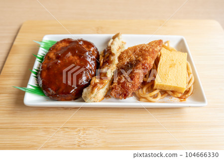 Japanese hamburger steak, fried fish and Japanese rolled omelet on white plate Japanese hamburger steak, fried fish and Japanese rolled omelet on white plate 104666330