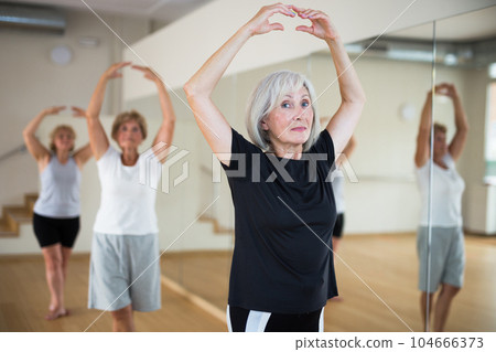 Senior women in sportswear dancing ballet inside gym 104666373
