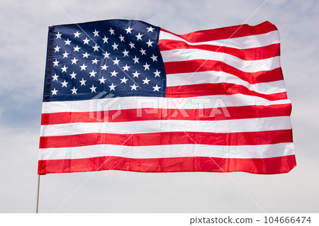 Large USA flag waving against sky 104666474