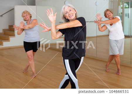 Mature active women practice vigorous swing 104666531