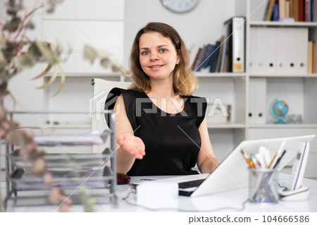 Business woman invites visitor to go to reception in office Business woman invites visitor to go to reception in office 104666586