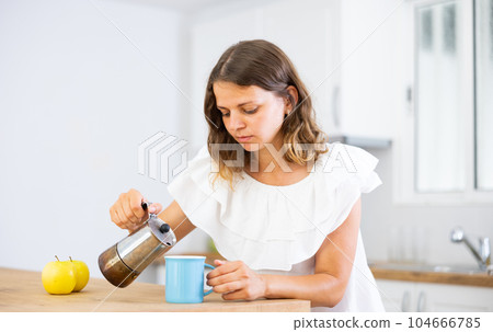 Woman pouring coffee in morning at home Woman pouring coffee in morning at home 104666785