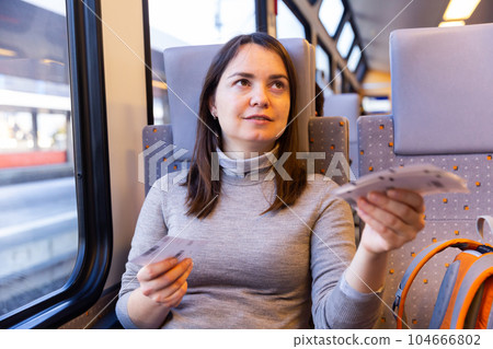 Woman showing tickets to attendant in train Woman showing tickets to attendant in train 104666802