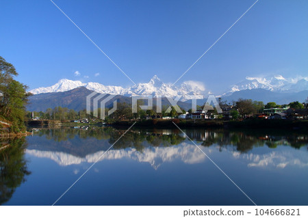 Pokhara, Nepal in South Asia View of Machapuchare and Annapurna mountain range from the dam side and the water mirror of Fewa Lake Pokhara, Nepal in South Asia View of Machapuchare and Annapurna mountain range from the dam side and the water mirror of Fewa Lake 104666821