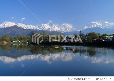Pokhara, Nepal in South Asia View of Machapuchare and Annapurna mountain range from the dam side and the water mirror of Fewa Lake 104666826