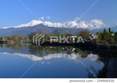 Pokhara, Nepal in South Asia View of Machapuchare and Annapurna mountain range from the dam side and the water mirror of Fewa Lake 104666830