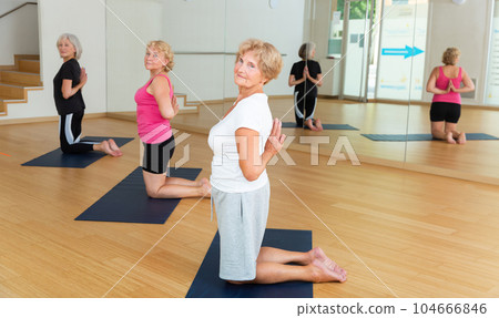 Mature women standing on knees with hands behind back 104666846