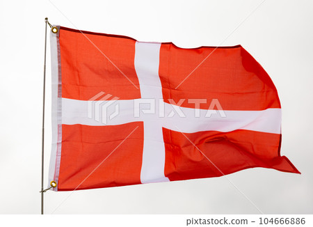 Danish flag flying beautifully in wind with gray sky behind 104666886