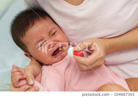 sick infant baby crying while refuses eating liquid medicine with dropper sick infant baby crying while refuses eating liquid medicine with dropper 104667301