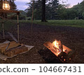 Bonfire, lantern and lots of firewood in the evening forest 104667431