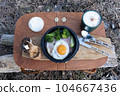 Fried eggs and cappuccino in a wooden basket outdoors 104667436