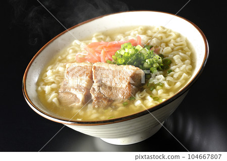 黑色背景下的熱沖繩蕎麥麵,配有排骨、大量小蔥和醃姜 黑色背景下的熱沖繩蕎麥麵,配有排骨、大量小蔥和醃姜 104667807