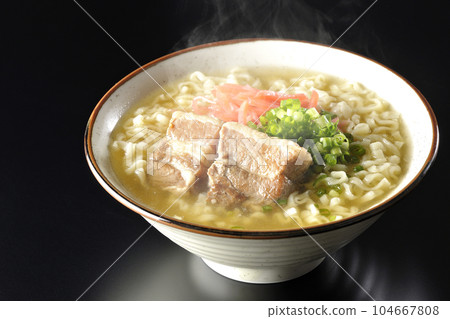 黑色背景下的熱沖繩蕎麥麵,配有排骨、大量小蔥和醃姜 黑色背景下的熱沖繩蕎麥麵,配有排骨、大量小蔥和醃姜 104667808