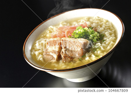 黑色背景下的熱沖繩蕎麥麵,配有排骨、大量小蔥和醃姜 黑色背景下的熱沖繩蕎麥麵,配有排骨、大量小蔥和醃姜 104667809