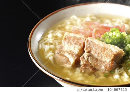 黑色背景下的熱沖繩蕎麥麵,配有排骨、大量小蔥和醃姜 黑色背景下的熱沖繩蕎麥麵,配有排骨、大量小蔥和醃姜 104667813