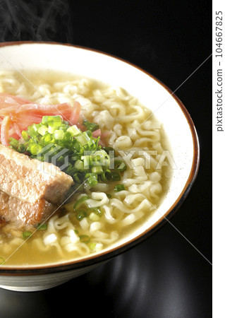 黑色背景下的熱沖繩蕎麥麵,配有排骨、大量小蔥和醃姜 黑色背景下的熱沖繩蕎麥麵,配有排骨、大量小蔥和醃姜 104667825