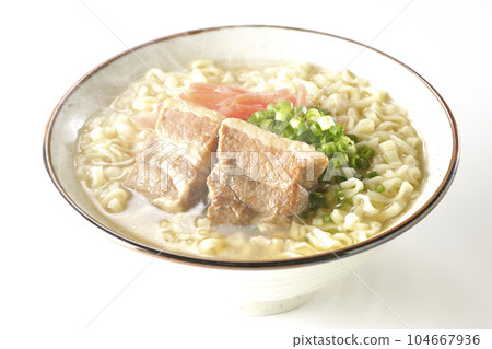 Piping hot Okinawa soba with pork belly, plenty of small green onions and red pickled ginger, photographed against a white background 104667936