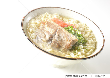 Piping hot Okinawa soba with pork belly, plenty of small green onions and red pickled ginger, photographed against a white background 104667940