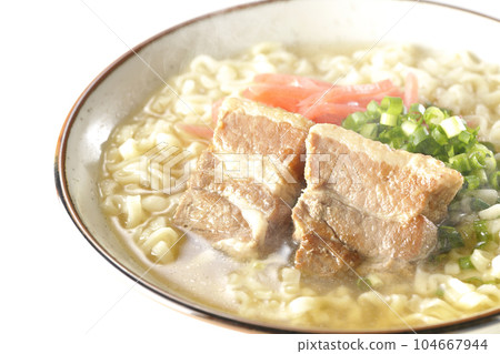 Piping hot Okinawa soba with pork belly, plenty of small green onions and red pickled ginger, photographed against a white background 104667944