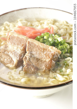 Piping hot Okinawa soba with pork belly, plenty of small green onions and red pickled ginger, photographed against a white background 104667955