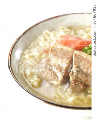 Piping hot Okinawa soba with pork belly, plenty of small green onions and red pickled ginger, photographed against a white background 104667956